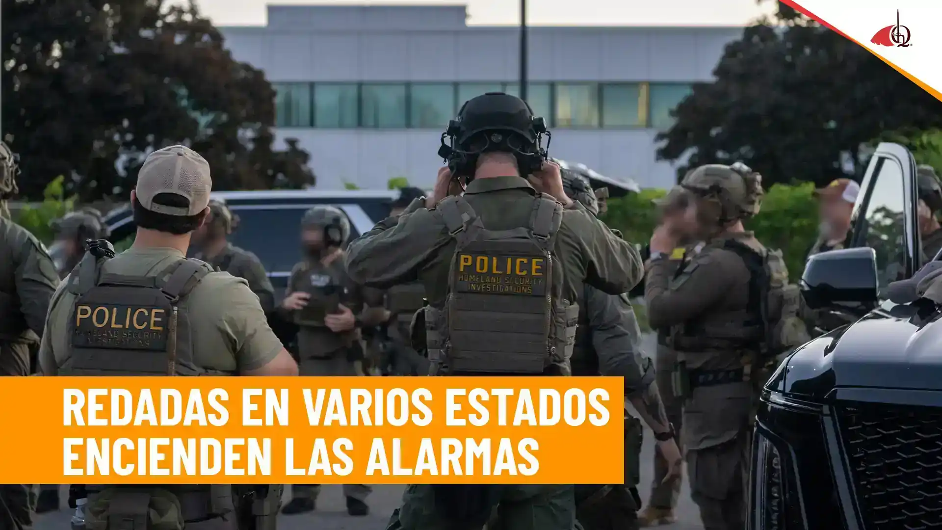 Agentes policiales armados reunidos frente a un edificio durante un operativo