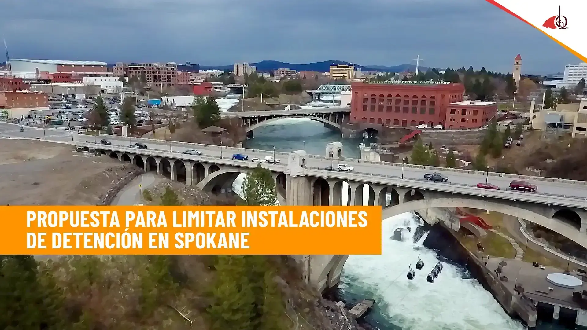 Vista aérea de Spokane con el puente sobre el río y el texto “Propuesta para limitar instalaciones de detención en Spokane”